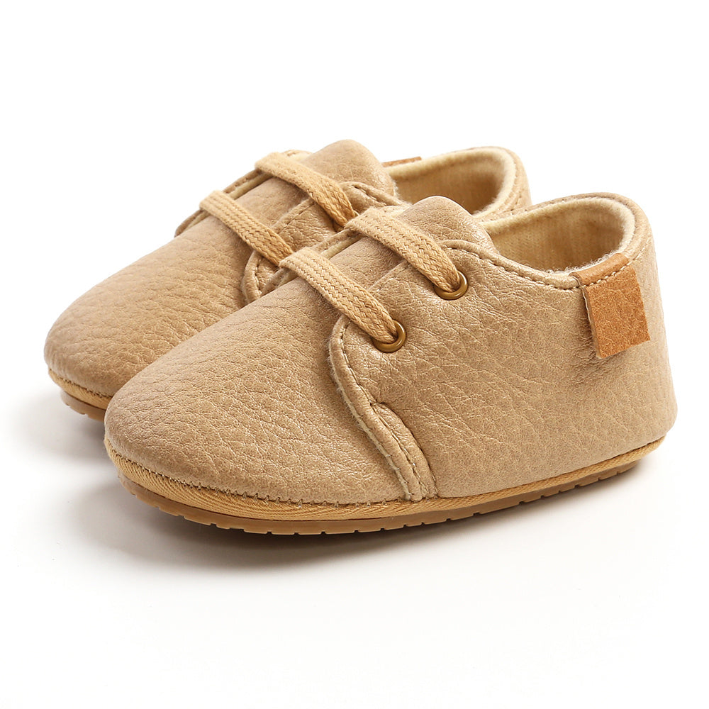 Baby crawling while wearing gender-neutral shoes