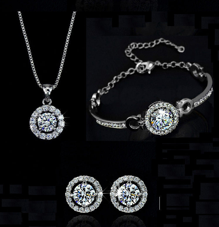 Gold necklace, earrings, and bracelet set displayed on white background
