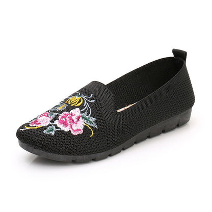 Woman wearing lightweight embroidered cloth shoes on sidewalk

