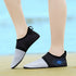 Feet in aqua socks standing at the edge of a pool

